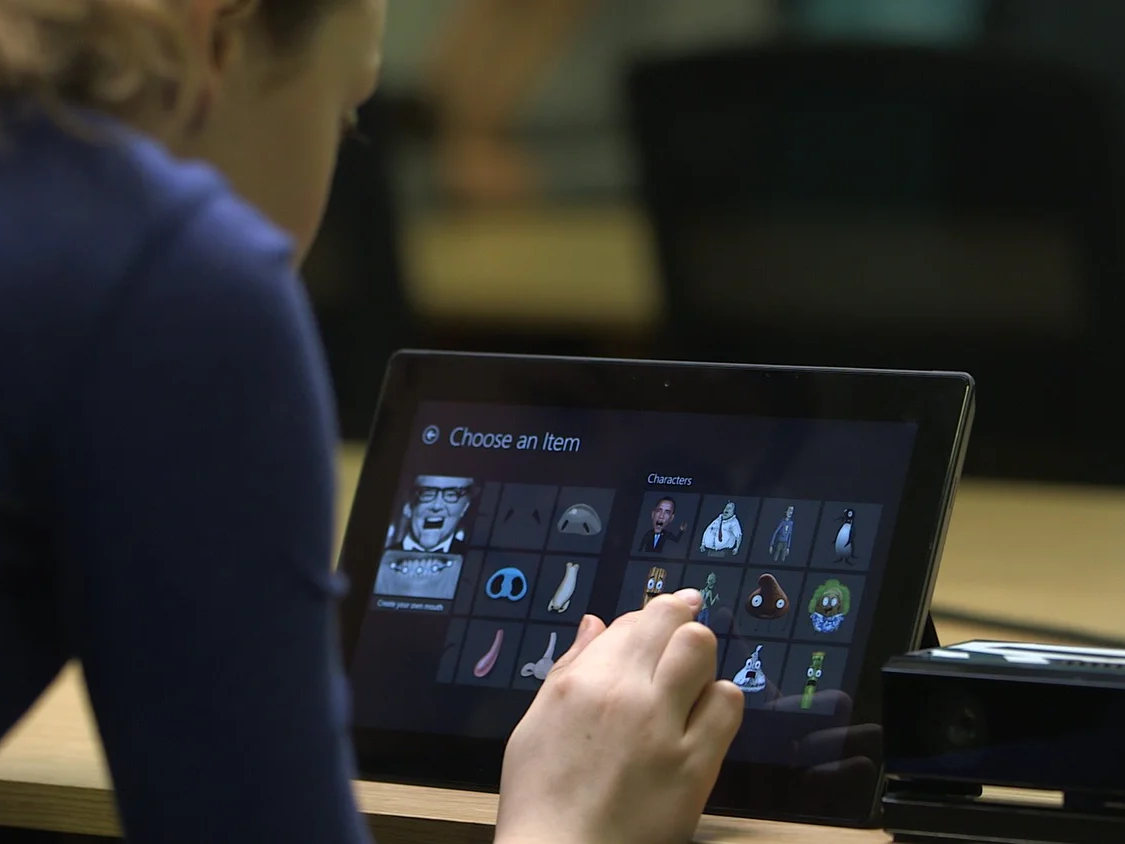 A child using YAKiT on a tablet beside a Kinect sensor