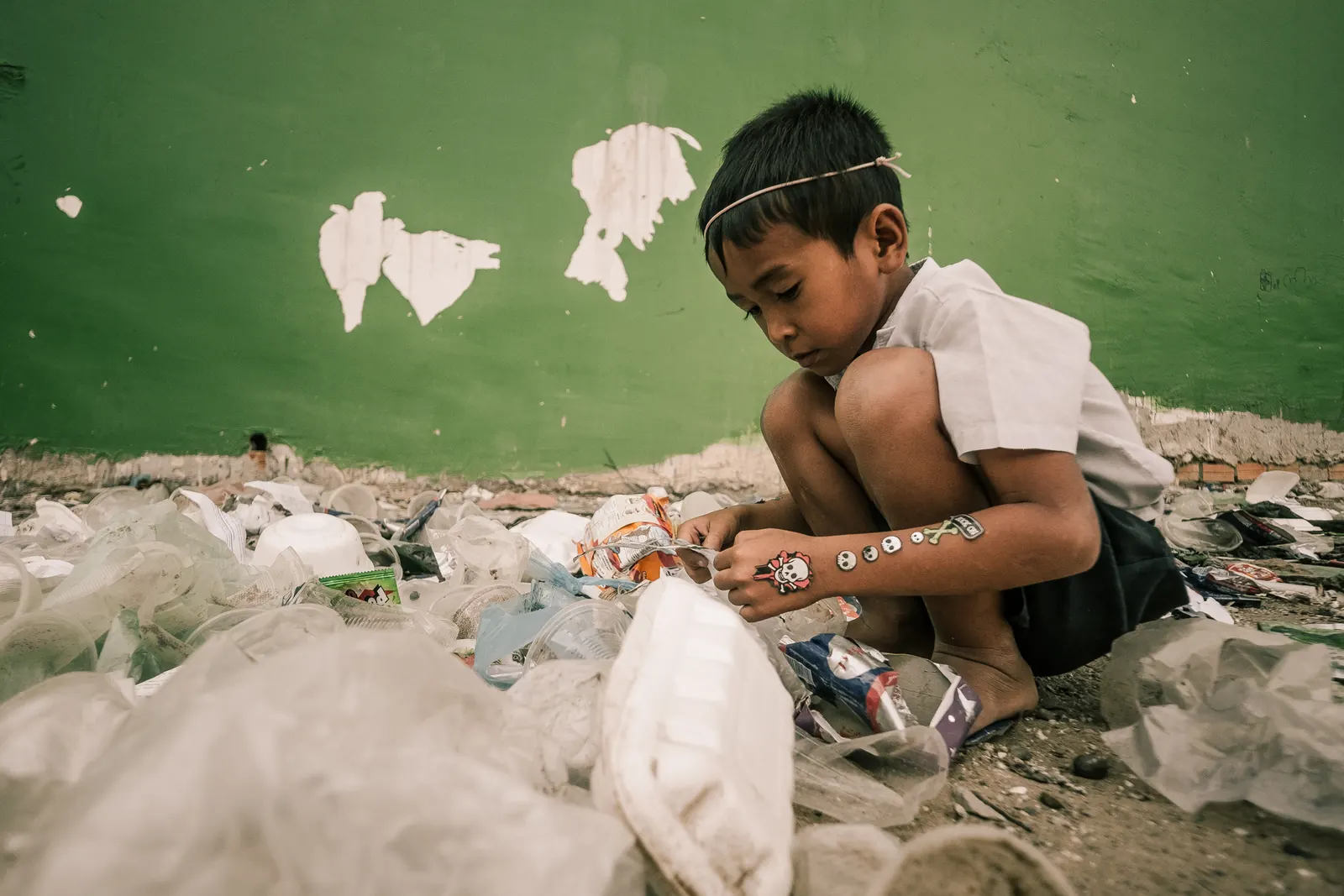 A child building a kite from discarded packaging