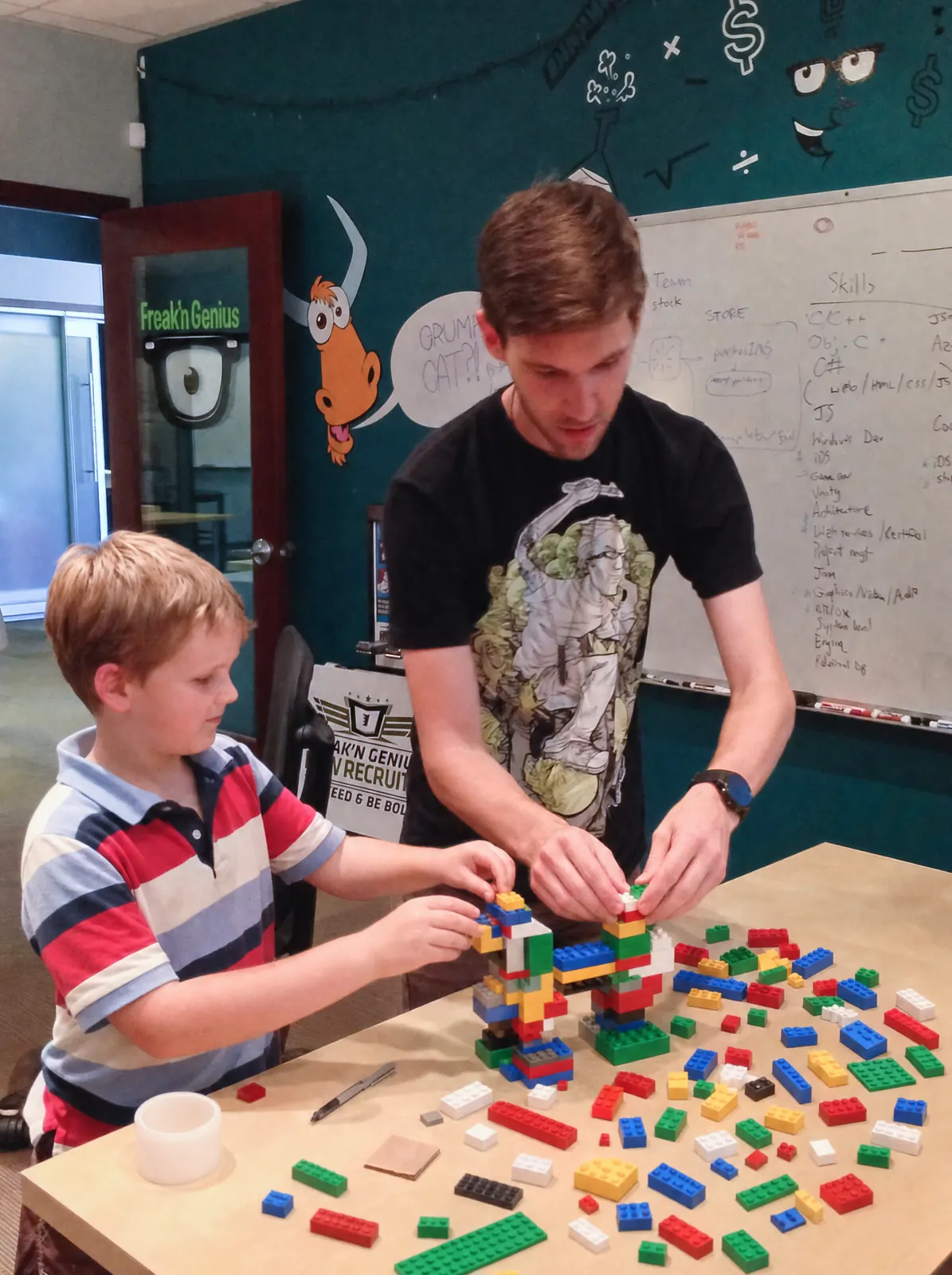 Kyle and a boy building with bricks at the Freak'n Genius office
