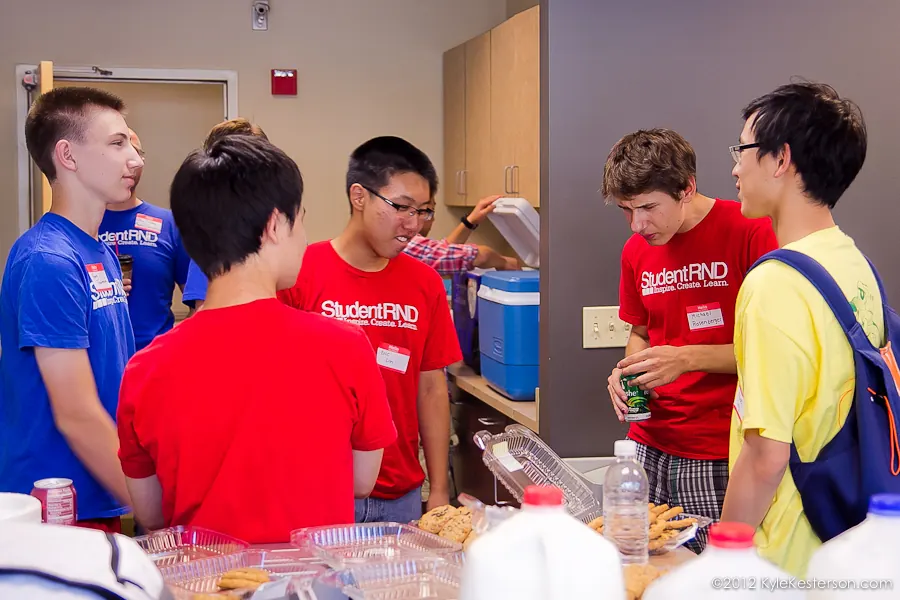 StudentRND participants talking around a table of snacks