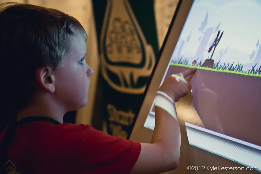A boy drawing directly on a large touchscreen at a Startup Weekend event